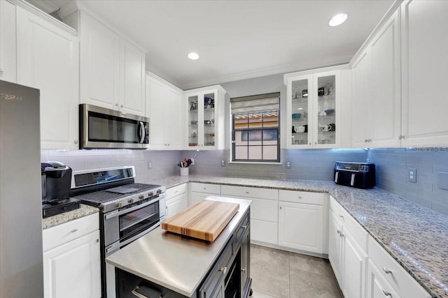 10450 Highland Park Pl, Palmetto, FL 34221 - kitchen featuring stainless steel appliances, white cabinets, backsplash, light tile patterned floors, and recessed lighting
