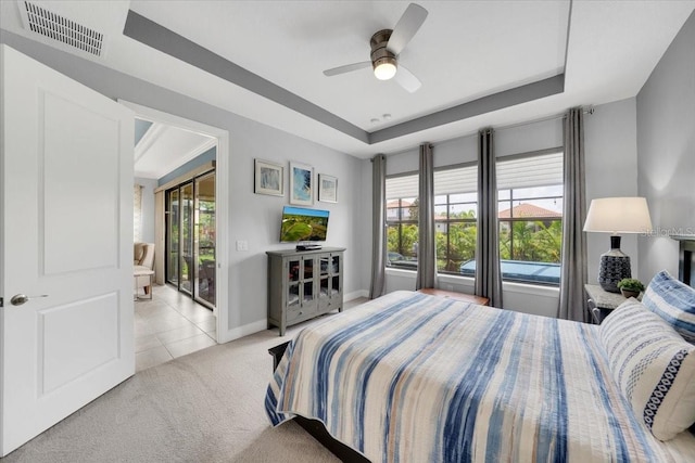 10450 Highland Park Pl, Palmetto, FL 34221 - carpeted bedroom featuring a tray ceiling, multiple windows, tile patterned floors, and ceiling fan