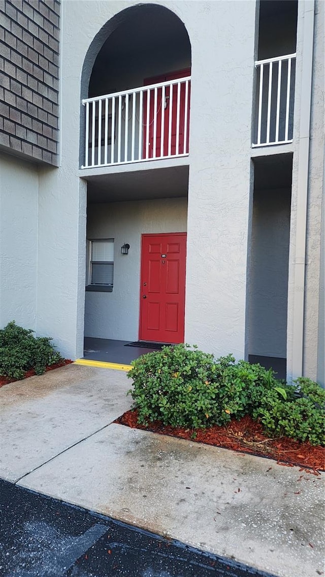 3123 29th Ave N Unit 105, Saint Petersburg, FL 33713 - view of exterior entry with stucco siding and a balcony