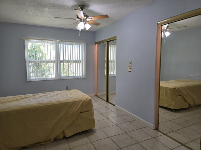 3123 29th Ave N Unit 105, Saint Petersburg, FL 33713 - bedroom featuring light tile patterned flooring, two closets, a textured ceiling, and a ceiling fan