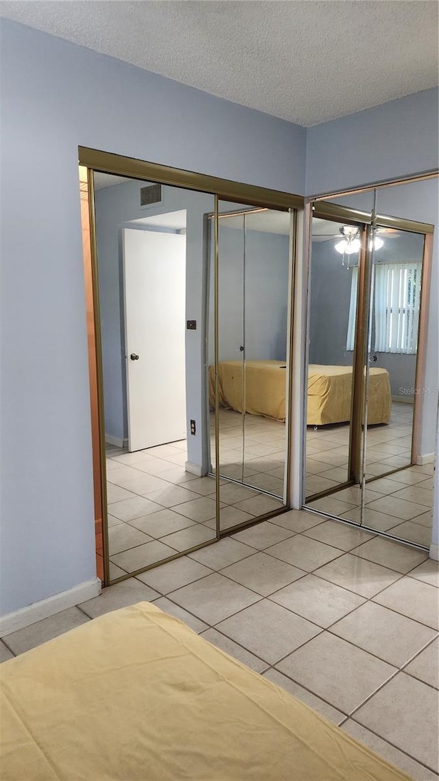 3123 29th Ave N Unit 105, Saint Petersburg, FL 33713 - unfurnished bedroom featuring light tile patterned floors, multiple closets, and a textured ceiling