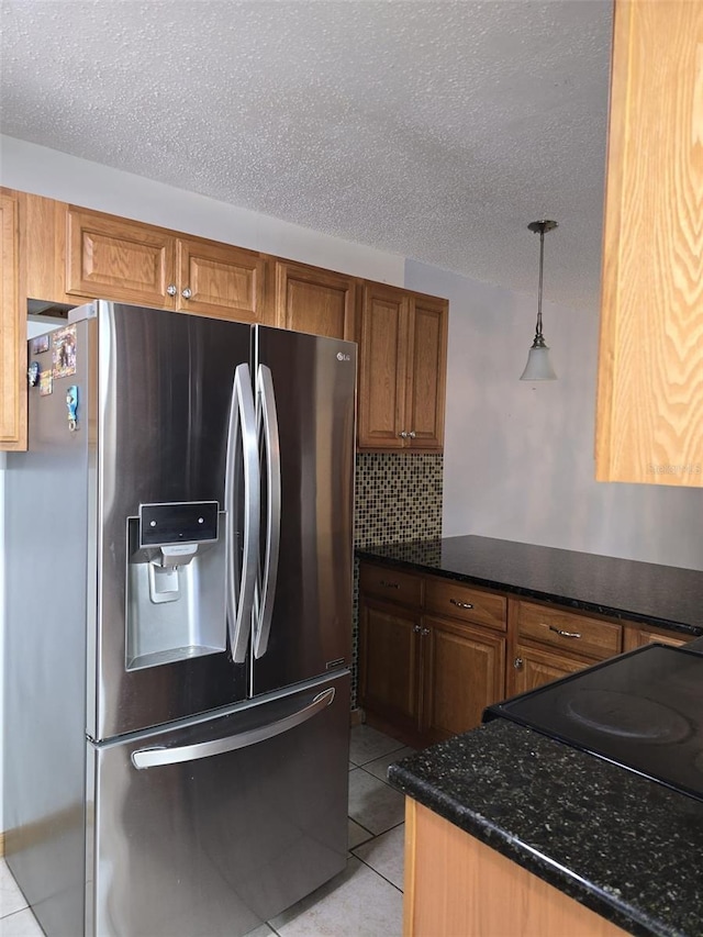 3123 29th Ave N Unit 105, Saint Petersburg, FL 33713 - kitchen featuring stainless steel fridge, a textured ceiling, light tile patterned floors, brown cabinets, and tasteful backsplash