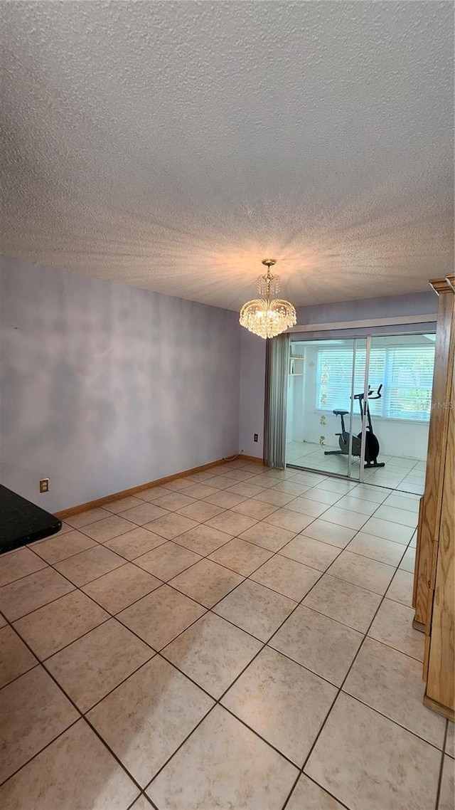 3123 29th Ave N Unit 105, Saint Petersburg, FL 33713 - empty room featuring light tile patterned flooring, a textured ceiling, and a chandelier