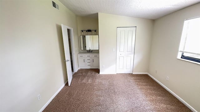 4003 Oak Limb Ct, Tampa, FL 33614 - unfurnished bedroom with carpet floors, a closet, and a textured ceiling