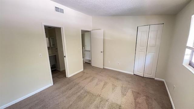 4003 Oak Limb Ct, Tampa, FL 33614 - unfurnished bedroom with carpet floors, a textured ceiling, a closet, lofted ceiling, and ensuite bath