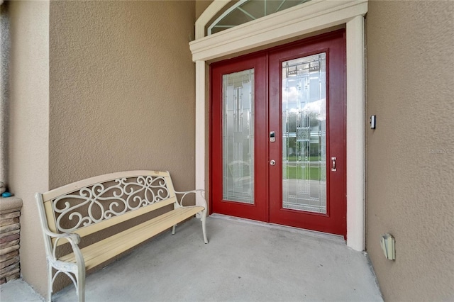 13102 Done Groven Dr, Dover, FL 33527 - view of exterior entry featuring stucco siding and french doors