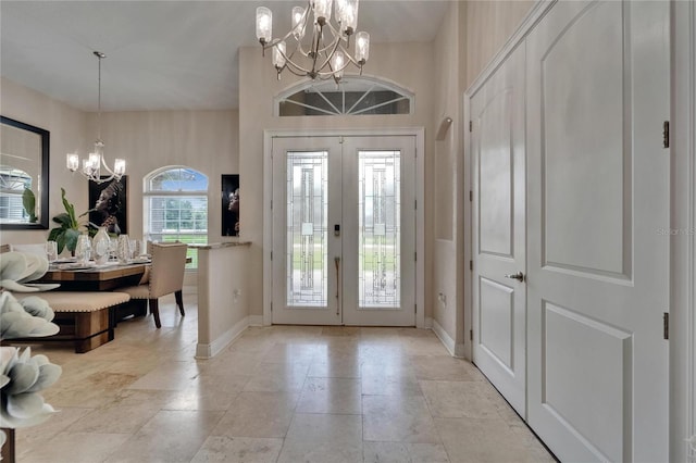 13102 Done Groven Dr, Dover, FL 33527 - entrance foyer with a chandelier, light stone finish floors, and french doors