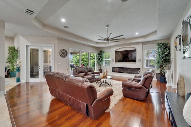13102 Done Groven Dr, Dover, FL 33527 - living area with a raised ceiling, wood finished floors, french doors, a ceiling fan, and a textured ceiling