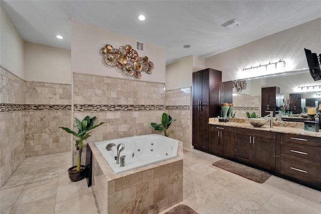 13102 Done Groven Dr, Dover, FL 33527 - bathroom featuring a jetted tub, vanity, tile walls, and recessed lighting