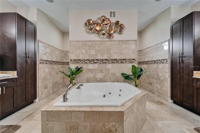 13102 Done Groven Dr, Dover, FL 33527 - full bathroom with vanity, tile walls, and a jetted tub