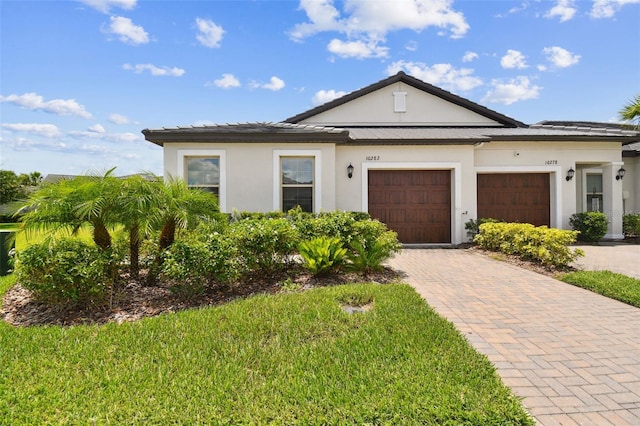 10282 Echo Dock Loop, San Antonio, FL 33576 - view of front of property with a garage, stucco siding, decorative driveway, and a front lawn