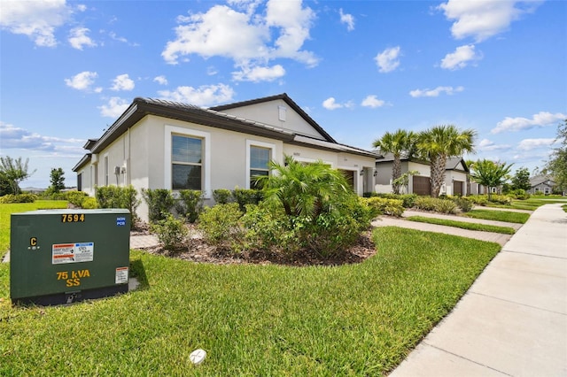 10282 Echo Dock Loop, San Antonio, FL 33576 - view of home's exterior with an attached garage, stucco siding, and a lawn