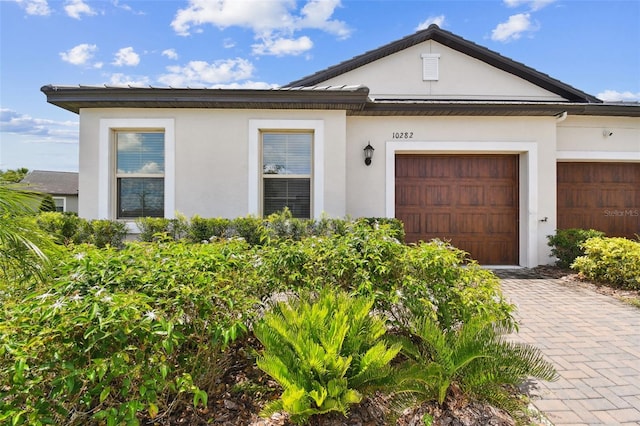 10282 Echo Dock Loop, San Antonio, FL 33576 - view of front of house with stucco siding, a garage, and driveway