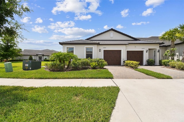 10282 Echo Dock Loop, San Antonio, FL 33576 - view of front facade featuring a front yard, decorative driveway, an attached garage, and stucco siding