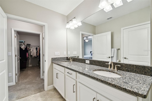10282 Echo Dock Loop, San Antonio, FL 33576 - ensuite bathroom featuring double vanity, a walk in closet, and a ceiling fan