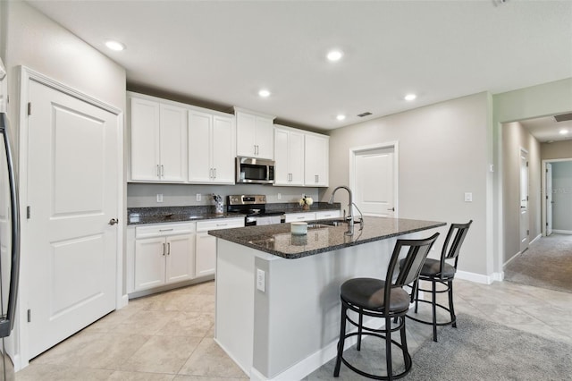 10282 Echo Dock Loop, San Antonio, FL 33576 - kitchen featuring stainless steel appliances, a kitchen island with sink, white cabinetry, and recessed lighting