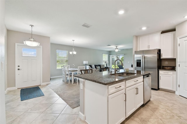 10282 Echo Dock Loop, San Antonio, FL 33576 - kitchen featuring dark stone counters, appliances with stainless steel finishes, white cabinets, hanging light fixtures, and recessed lighting