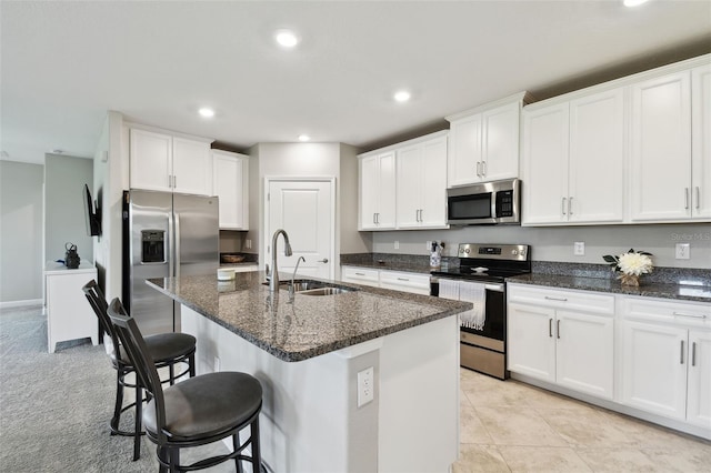 10282 Echo Dock Loop, San Antonio, FL 33576 - kitchen featuring stainless steel appliances, recessed lighting, a breakfast bar area, white cabinetry, and dark stone counters