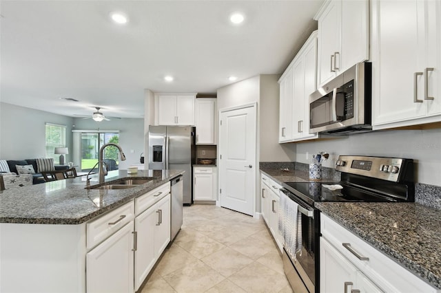 10282 Echo Dock Loop, San Antonio, FL 33576 - kitchen with appliances with stainless steel finishes, white cabinets, a ceiling fan, an island with sink, and recessed lighting