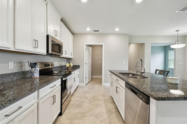 10282 Echo Dock Loop, San Antonio, FL 33576 - kitchen with appliances with stainless steel finishes, white cabinets, an island with sink, recessed lighting, and dark stone counters