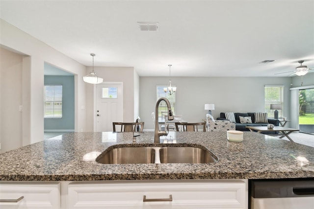 10282 Echo Dock Loop, San Antonio, FL 33576 - kitchen featuring stainless steel dishwasher, open floor plan, dark stone countertops, and healthy amount of natural light
