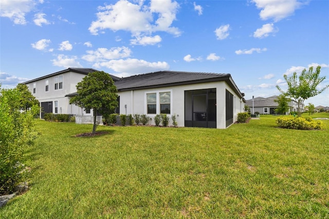 10282 Echo Dock Loop, San Antonio, FL 33576 - rear view of property featuring stucco siding, a lawn, and a sunroom