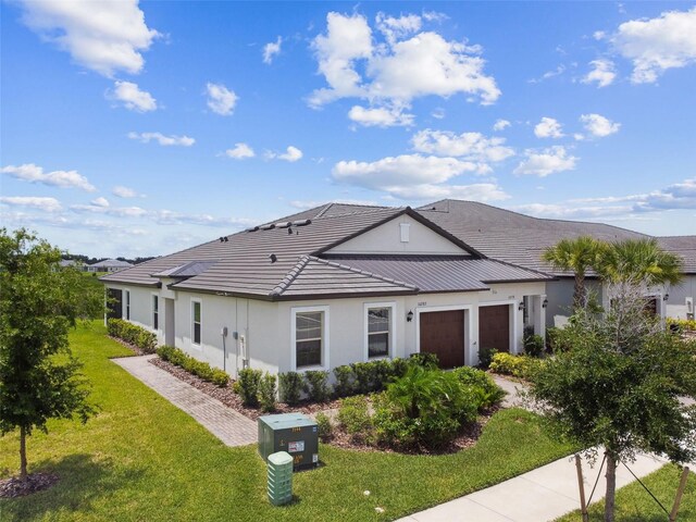 10282 Echo Dock Loop, San Antonio, FL 33576 - view of front facade with an attached garage, stucco siding, and a front lawn