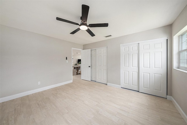 2905 Forest Cir, Seffner, FL 33584 - unfurnished bedroom with multiple closets, light wood finished floors, and a ceiling fan