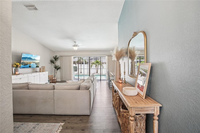 852 Crystal Dr, Palm Harbor, FL 34683 - living area featuring a textured wall, wood finished floors, lofted ceiling, a ceiling fan, and a textured ceiling