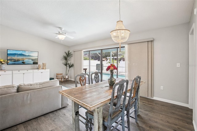 852 Crystal Dr, Palm Harbor, FL 34683 - dining room featuring wood finished floors, a chandelier, a ceiling fan, and vaulted ceiling
