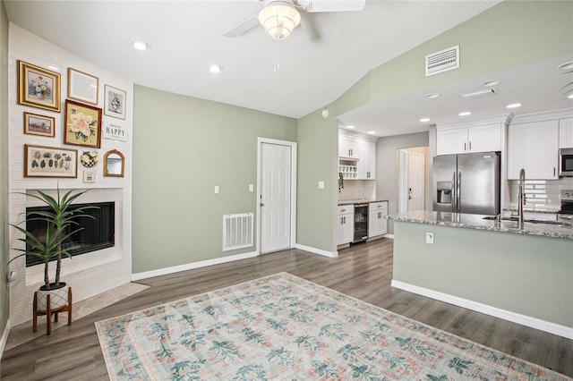 852 Crystal Dr, Palm Harbor, FL 34683 - kitchen featuring stainless steel appliances, beverage cooler, white cabinets, ceiling fan, and dark wood finished floors