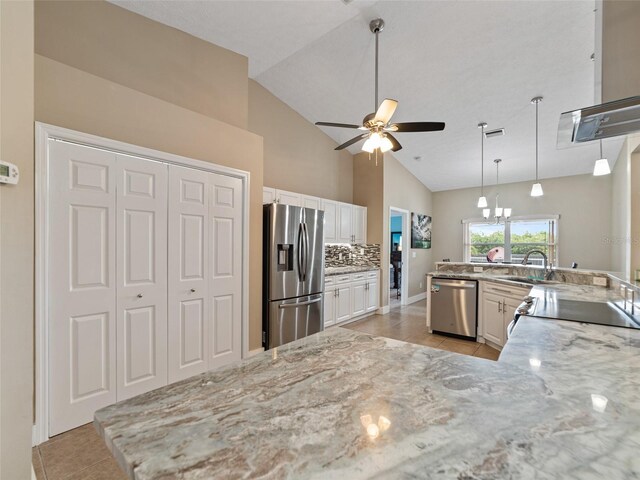 9702 Mary Robin Dr, Riverview, FL 33569 - kitchen featuring stainless steel appliances, light tile patterned flooring, a ceiling fan, light stone counters, and high vaulted ceiling