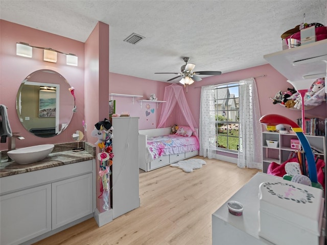 9702 Mary Robin Dr, Riverview, FL 33569 - bedroom featuring light wood finished floors, a textured ceiling, and ceiling fan