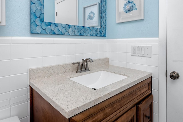 8584 111th St Unit 308, Seminole, FL 33772 - bathroom featuring vanity, tile walls, and a wainscoted wall