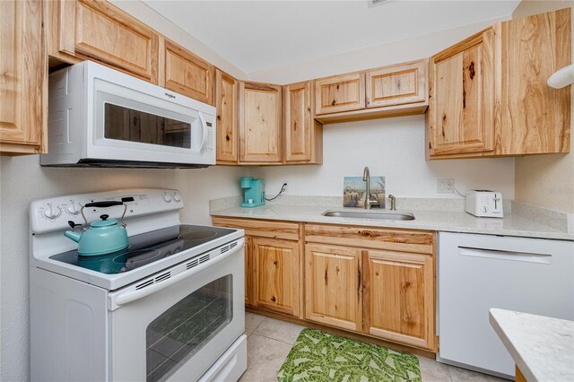 8584 111th St Unit 308, Seminole, FL 33772 - kitchen with white appliances, light countertops, light brown cabinetry, and light tile patterned floors