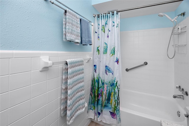 8584 111th St Unit 308, Seminole, FL 33772 - bathroom with shower / bath combination with curtain, tile walls, and a wainscoted wall