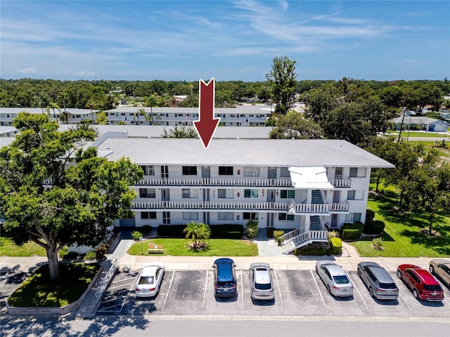 8584 111th St Unit 308, Seminole, FL 33772 - view of building exterior with uncovered parking and view of scattered trees