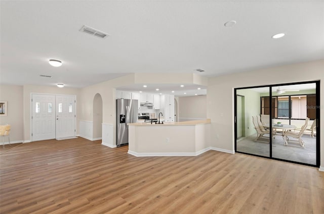 4530 Zack Dr, New Port Richey, FL 34653 - unfurnished living room featuring light wood finished floors, arched walkways, healthy amount of natural light, and recessed lighting