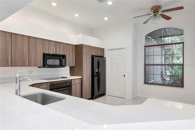 211 Arlington Ave E, Oldsmar, FL 34677 - kitchen with black appliances, light countertops, light tile patterned flooring, recessed lighting, and a ceiling fan