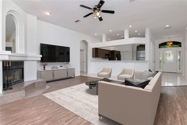 211 Arlington Ave E, Oldsmar, FL 34677 - living room featuring a ceiling fan, arched walkways, wood finished floors, a fireplace, and recessed lighting