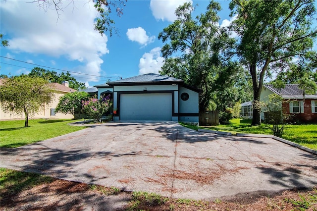 211 Arlington Ave E, Oldsmar, FL 34677 - view of front of house featuring a front yard, driveway, a garage, and stucco siding