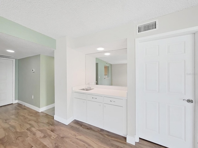 700 Starkey Rd Unit 311, Largo, FL 33771 - bathroom with wood finished floors, a textured ceiling, and vanity