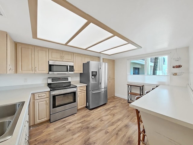700 Starkey Rd Unit 311, Largo, FL 33771 - kitchen with appliances with stainless steel finishes, light wood finished floors, light brown cabinets, and light countertops