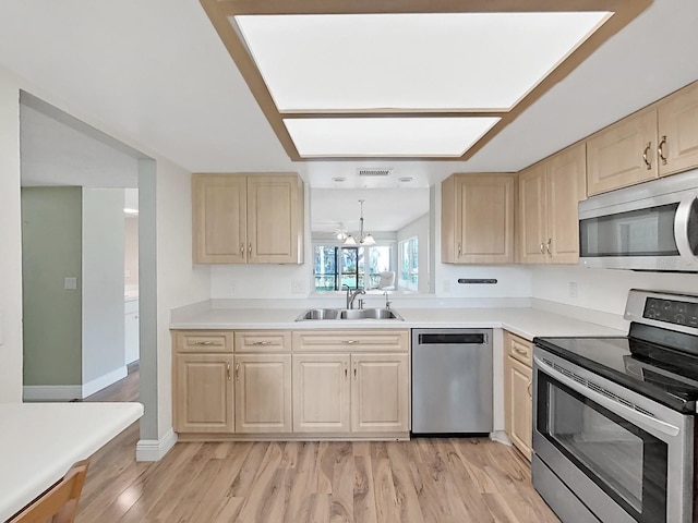 700 Starkey Rd Unit 311, Largo, FL 33771 - kitchen featuring appliances with stainless steel finishes, light brown cabinetry, light wood finished floors, and light countertops