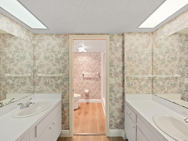 700 Starkey Rd Unit 311, Largo, FL 33771 - full bath featuring wood finished floors, two vanities, and a textured ceiling