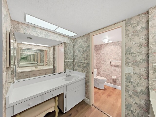 700 Starkey Rd Unit 311, Largo, FL 33771 - bathroom featuring wood finished floors, vanity, and a skylight