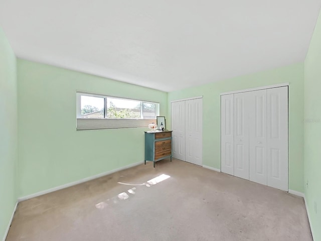 700 Starkey Rd Unit 311, Largo, FL 33771 - unfurnished bedroom featuring two closets and carpet floors