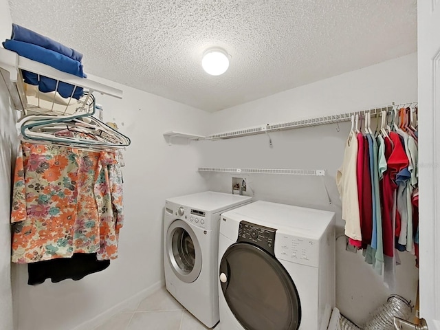 700 Starkey Rd Unit 311, Largo, FL 33771 - laundry area featuring washing machine and clothes dryer, a textured ceiling, and light tile patterned floors