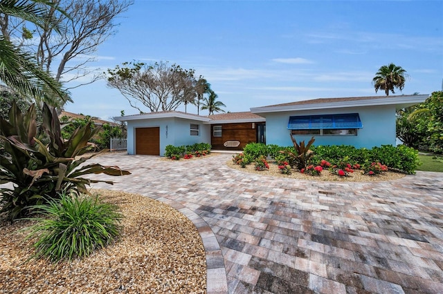 4381 Poinsettia Dr, St Pete Beach, FL 33706 - view of front of home featuring stucco siding, a garage, and driveway