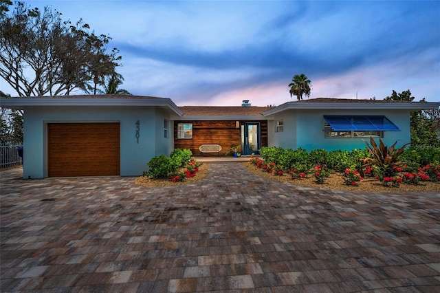 4381 Poinsettia Dr, St Pete Beach, FL 33706 - view of front facade with a garage, stucco siding, and decorative driveway